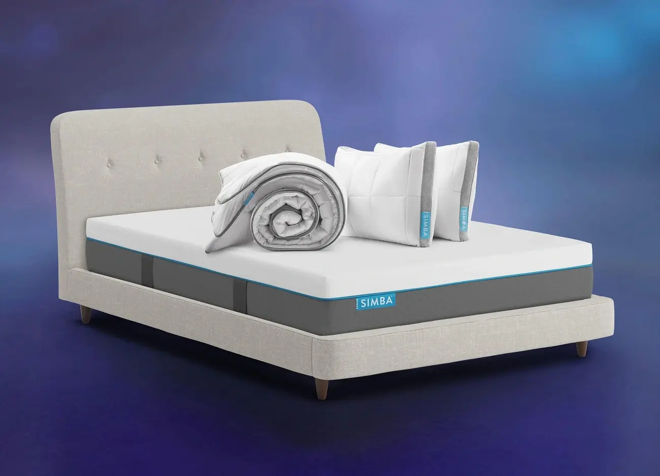 Simba Hybrid Essential mattress with pillows and duvet on a grey upholstered bed base
