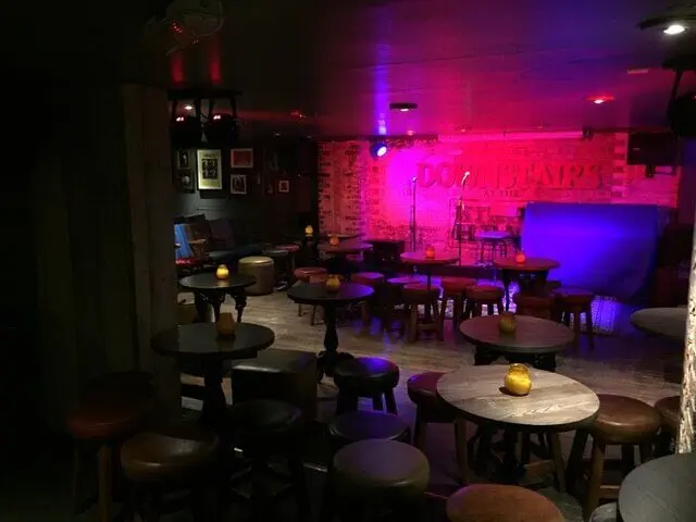 Intimate basement setting of one of the grassroots Comedy Clubs in London, with tables facing the stage