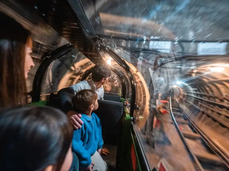 Family enjoying the immersive Mail Rail ride through historic underground tunnels at The Postal Museum, London