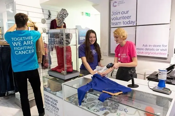 Interior view of a Cancer Research UK shop, one of many Thrift Shops London offers, with neatly organised clothing racks