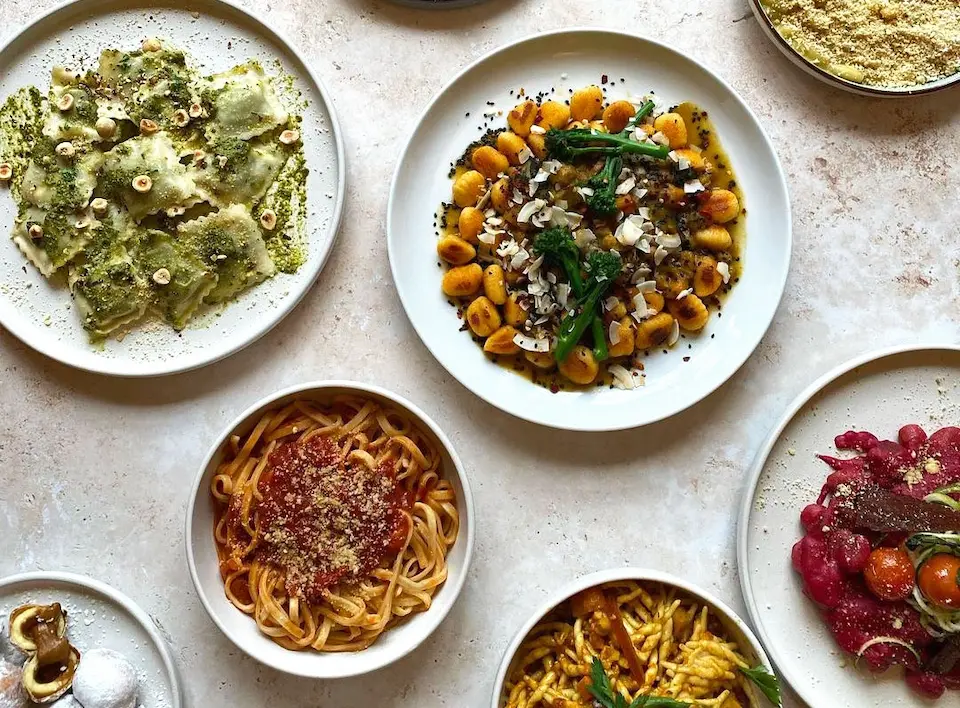 An overhead shot of several artisan vegan pasta dishes, including gnocchi and ravioli, from Pastan