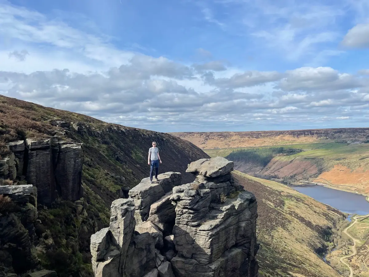Hiker standing carefully on The Trinnacles rock formation overlooking the reservoir
