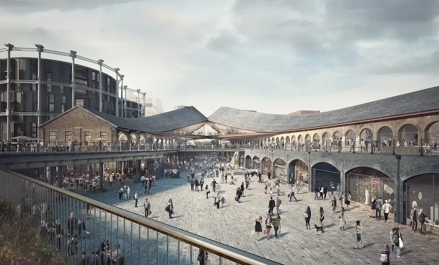 An architectural view of the bustling Coal Drops Yard in King's Cross, with its distinctive curved roofs and brick arches