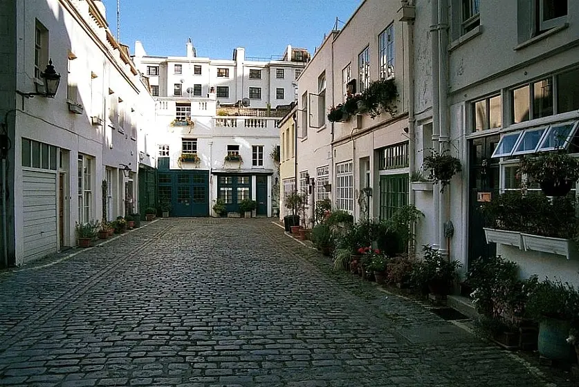 Charming cobbled mews street, Sussex Mews West in London, lined with traditional houses and potted plants