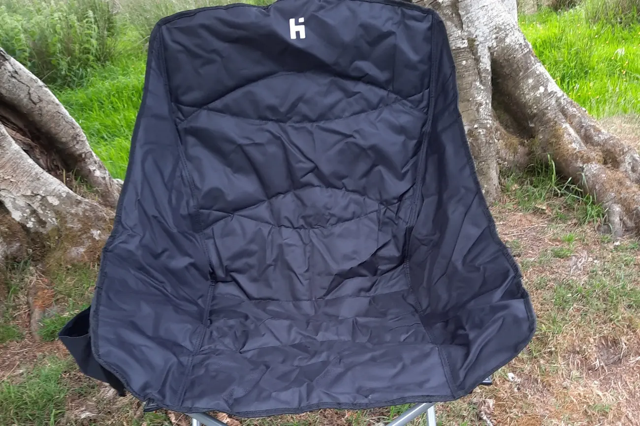 Black Hi-Gear Vegas XL bucket-style camping chair outdoors by tree roots