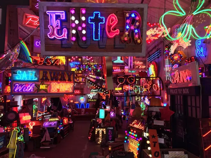 Dazzling interior of God's Own Junkyard filled with hundreds of vibrant vintage neon signs