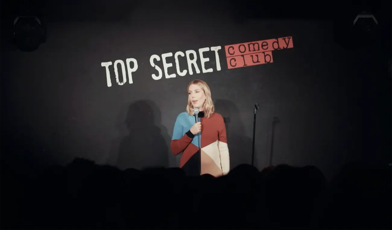 Female comedian performing stand-up on stage at the Top Secret Comedy Club in London