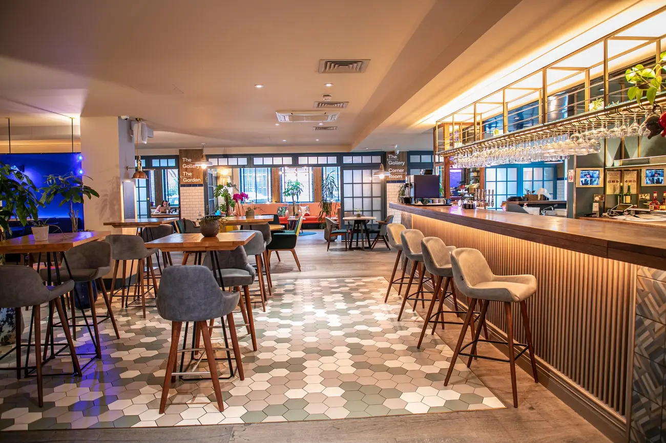 Stylish bar and lounge area at The Corner London City hotel with modern seating and hexagonal floor tiles