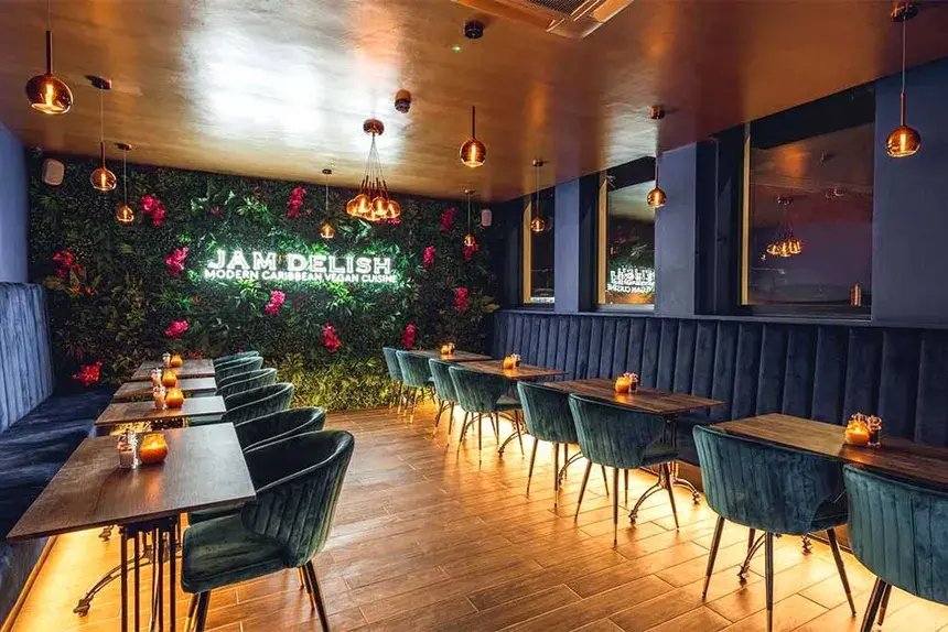 The sophisticated interior of Jam Delish, a modern Caribbean vegan restaurant with a lush plant wall