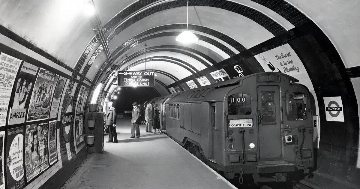 Black and white photo of an abandoned platform at Aldwych Tube Station with a vintage Piccadilly Line train
