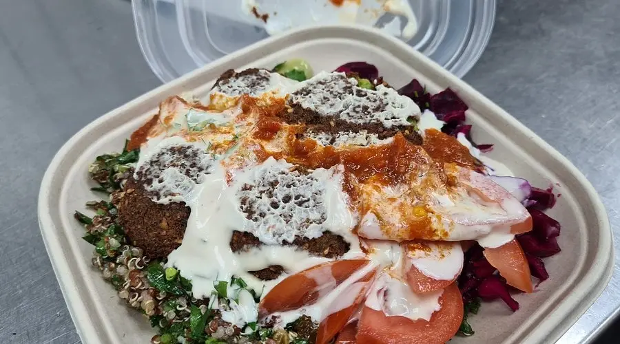 Close-up of Hibox takeaway box filled with falafel, quinoa, salad, and sauce