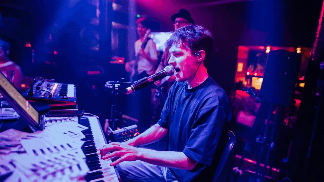 Musician playing keyboard and singing enthusiastically for a lively brunch crowd at The Piano Works