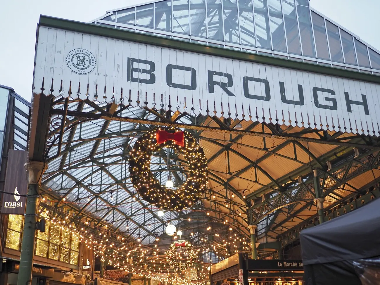 The iconic 'BOROUGH' sign at the entrance to Borough Market, decorated with a large, illuminated Christmas wreath