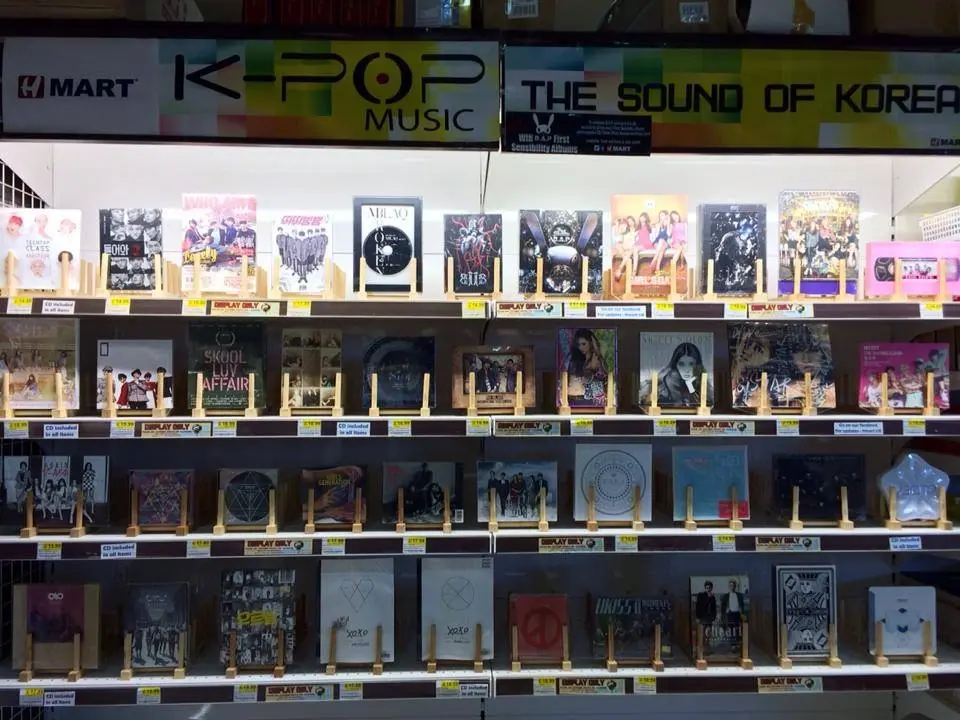 Shelves at H Mart displaying a wide variety of K-pop music albums from different artists